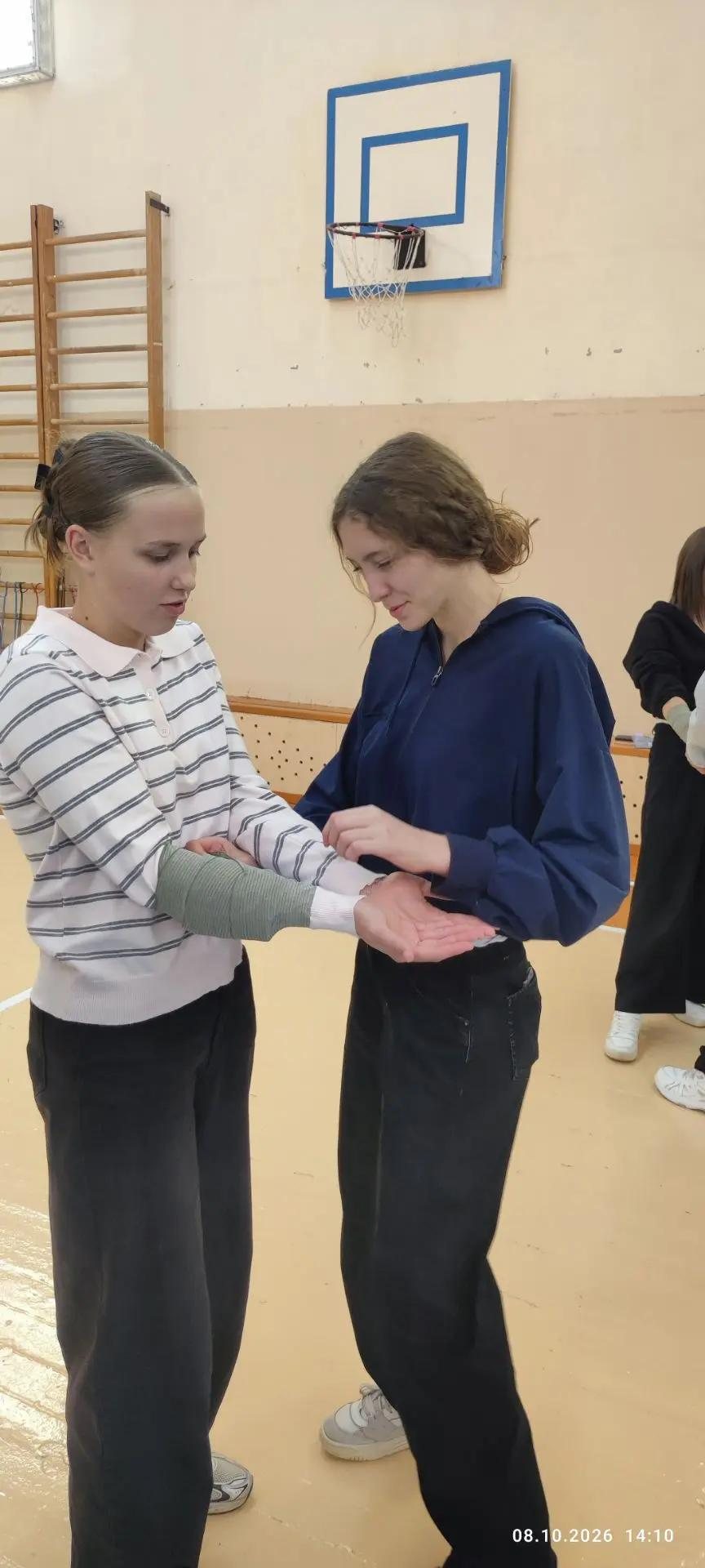 Ученицы отрабатывают наложение повязки на предплечье